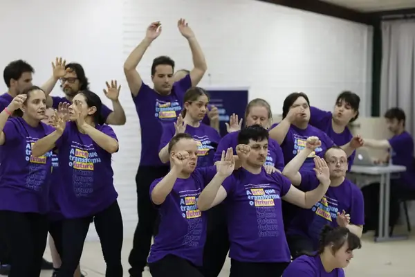 Grupo do Pertence com camisetas roxas do projeto A Arte que Transforma o Futuro em exercício cênico.