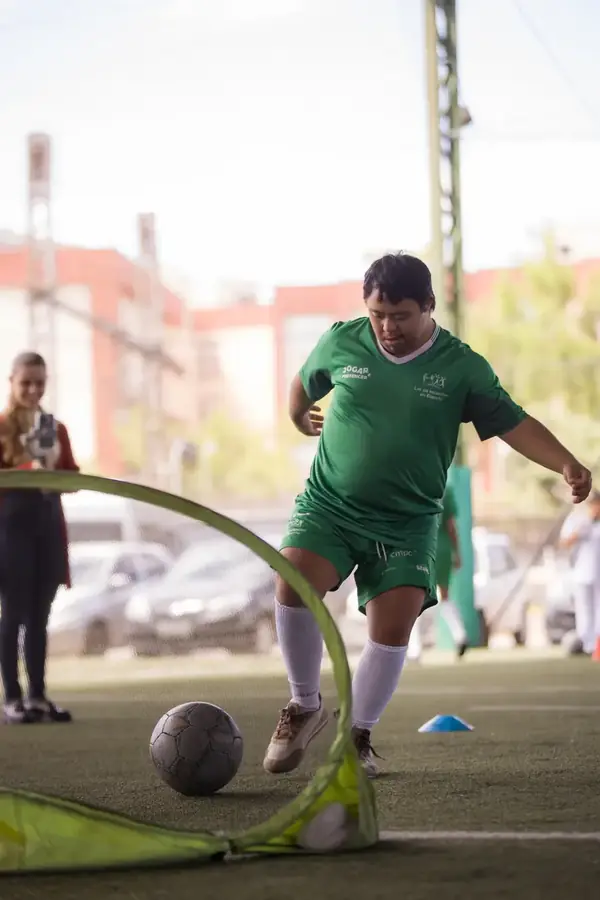Participante do projeto Jogar e Pertencer chuta a bola em direção ao gol.